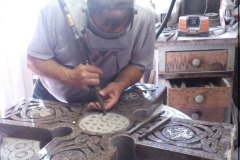 Photo of memorial maker hand carving lettering into stone